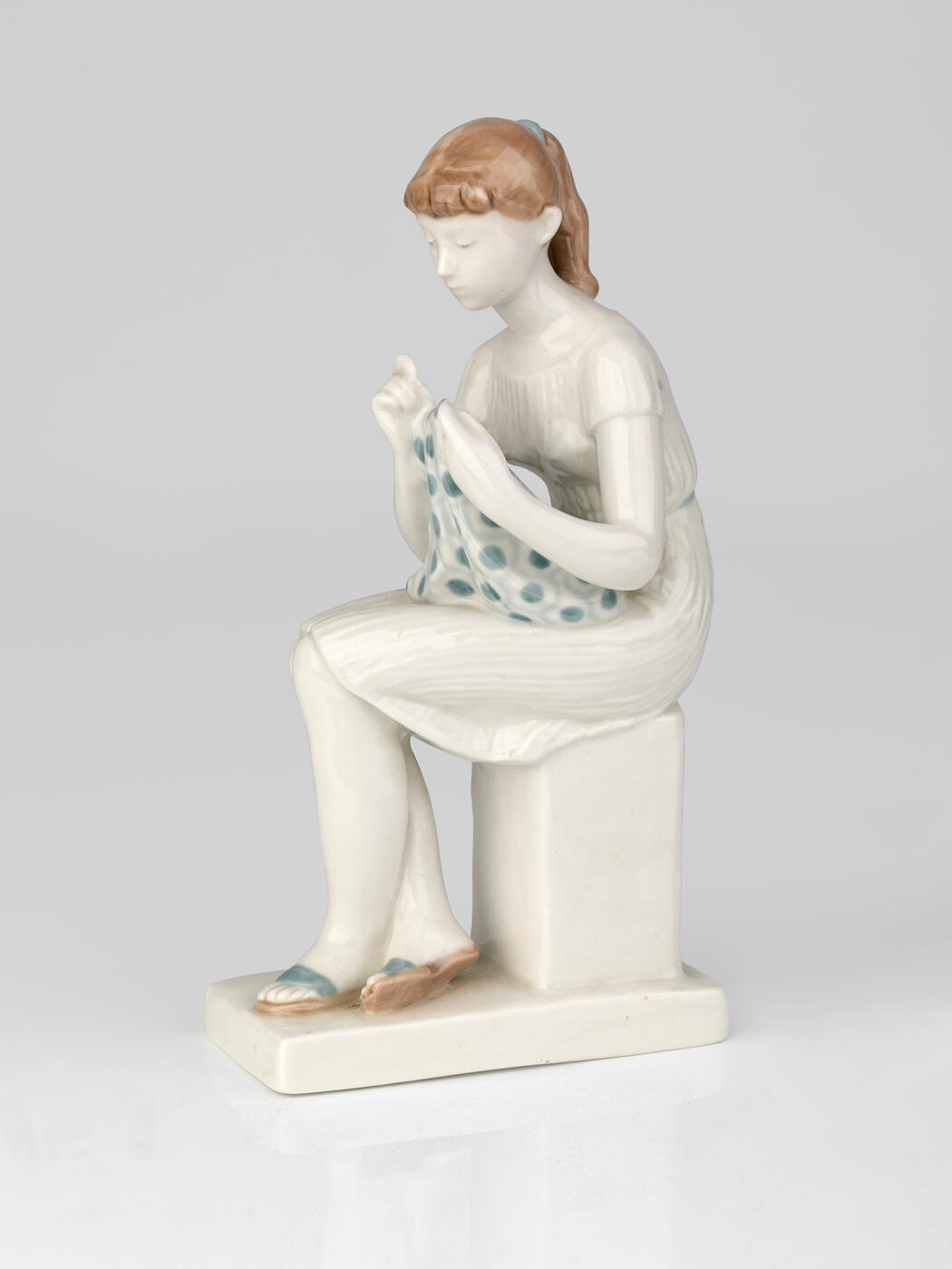 Porcelain figurine of a Girl Sewing